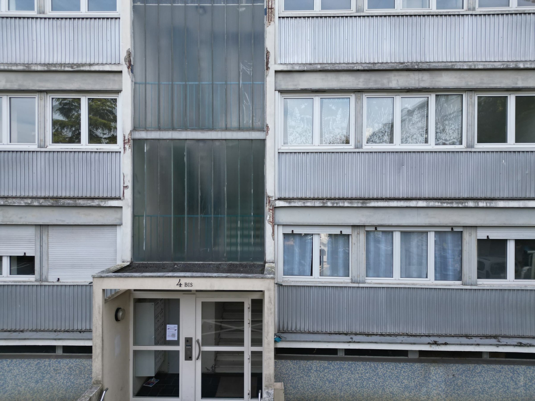 Une entrée et sa cage d'escalier vitrée, état existant (octobre 2025)
